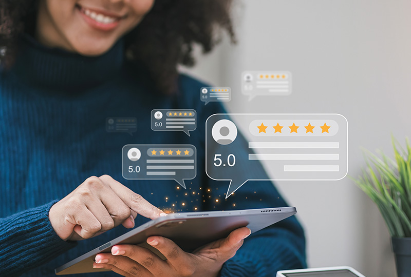 A woman interacting with a digital tablet displaying a chatbot interface with positive customer feedback icons.