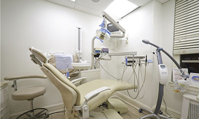 An image depicts a well-equipped dental office with modern dental chairs, a large window, and various pieces of medical equipment.